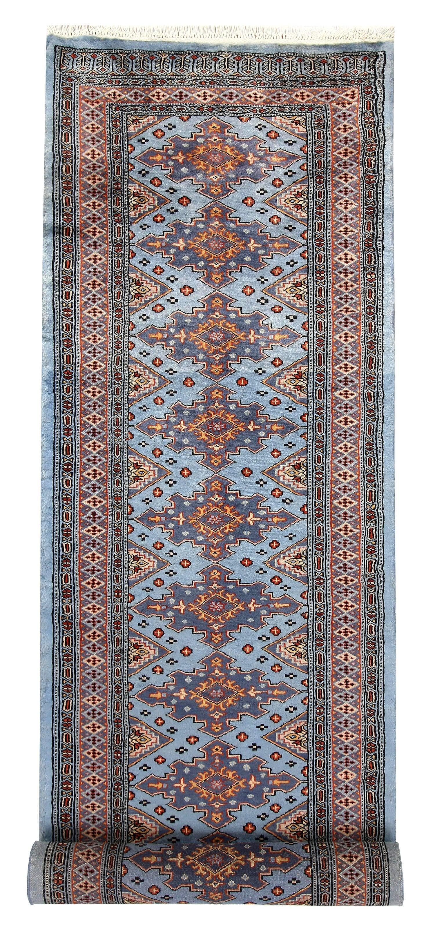 The Blue Mogal Sword wool hand-knotted area rug runner features bold sword motifs in rich blue tones. Its intricate craftsmanship and striking design add a regal and sophisticated touch to any hallway or space.